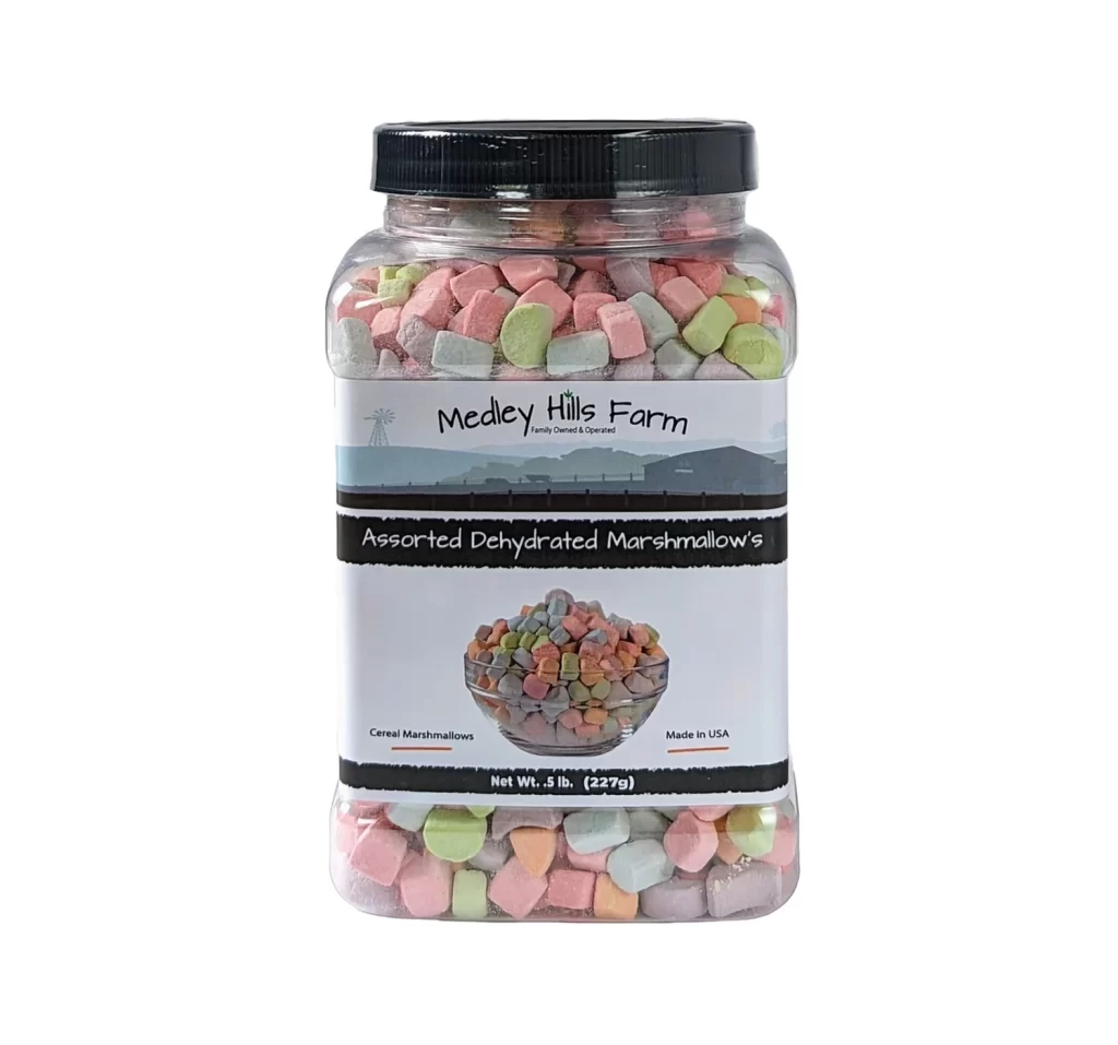 Large jar filled with multi colored marshmellows that are pink, blue, green, purple, and orange. The label says "Medley Hills Farm, Family Owned and Operated." Then it says "Assorted Dehydrated Marshmallow's." Towards the bottom it says "Cereal marshmallows" and "Made in USA". It also says "Net Wt. .5 lb. (227g)