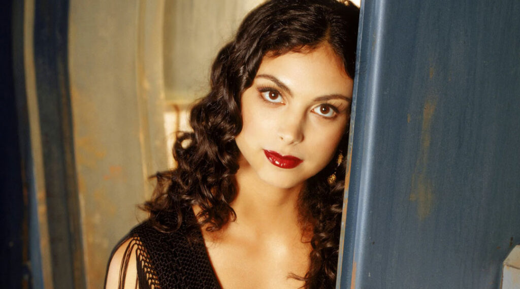 Monica Baccarin, an actress with long black curly hair and olive toned skin, portrays Inara Serra, a character in the TV show Firefly.