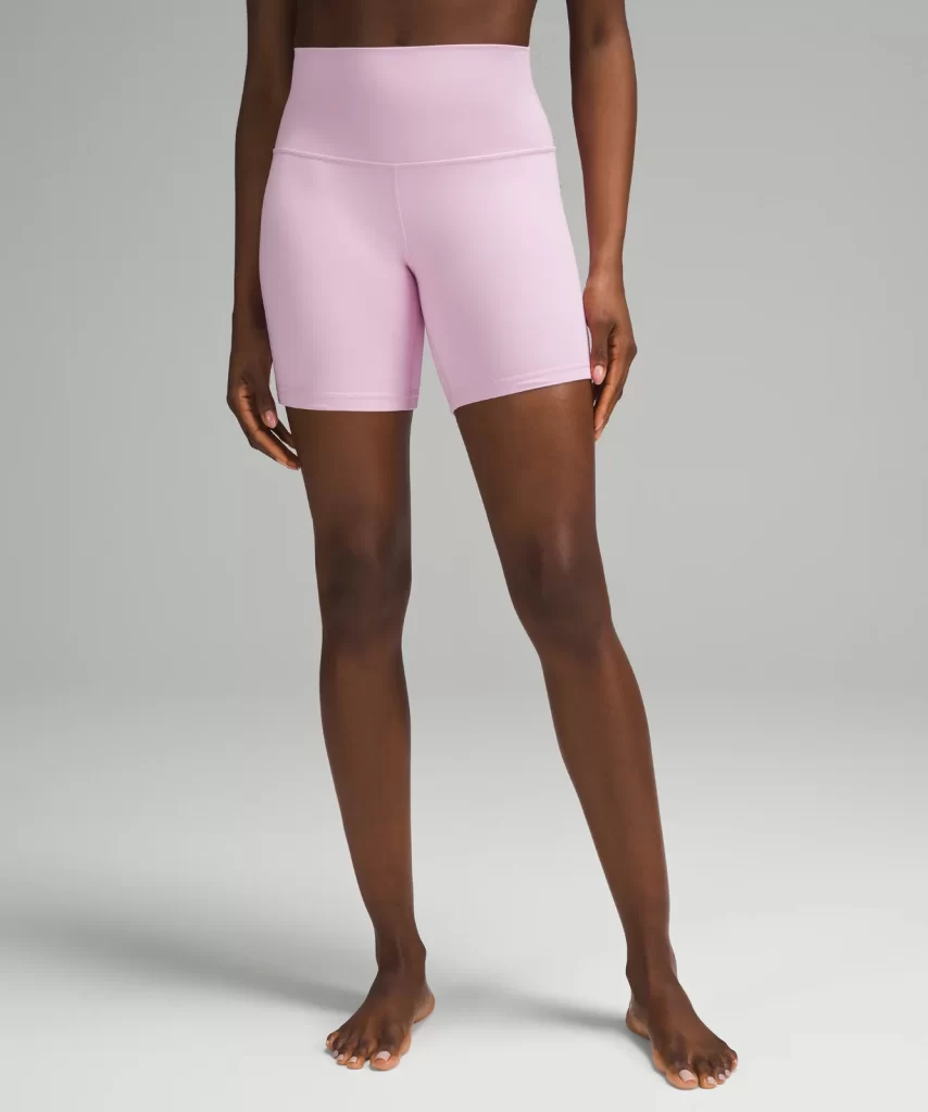 A Black woman's legs in sporty pink bike shorts. They are the Lululemon Align shorts 6 inches long.